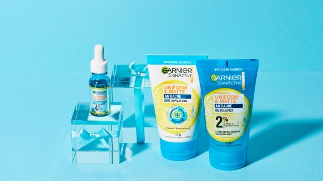 Produtos da linha Uniform & Matte de Garnier, focadas em tratamento antiacne e antioleosidade, posicionados lado a lado em frente a um fundo azul claro.