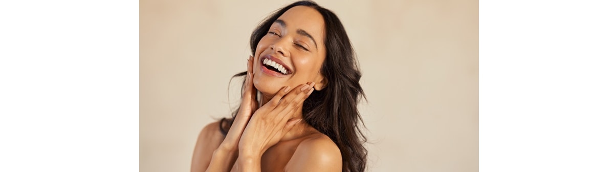 Mulher latina toca em sua pele facial hidratada com os benefícios do ácido hialurônico para a pele do rosto