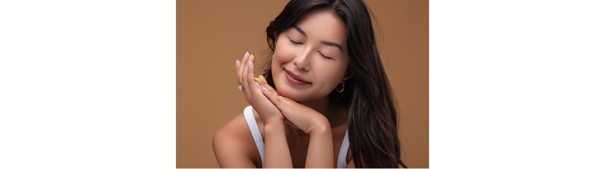 Mulher asiática com pele livre de manchas no rosto e manchas de acne que pode ser conquistada com um clareador de manchas