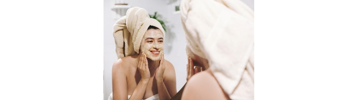 Mulher jovem utiliza um esfoliante para o rosto em sua rotina de skincare