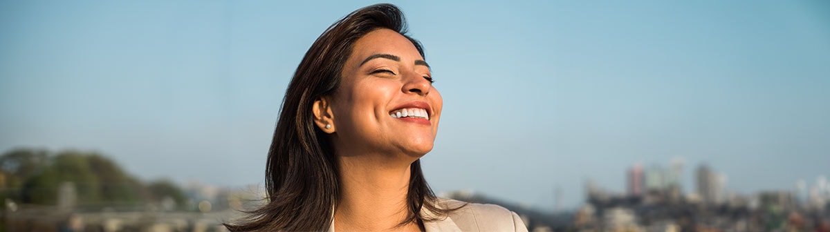 mulher de pele clara com cabelos lisos sorrindo com o semblante relaxado