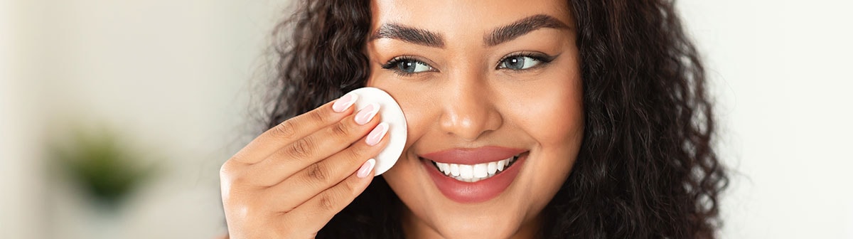 negra usando disco de algodão na face