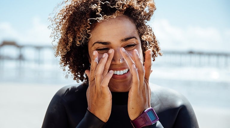 Mulher negra aplicando protetor solar para pele oleosa