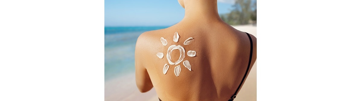 A mulher aplica protetor solar cremoso que é um dos tipos de protetor solar e que também incluem bastão, pó ou spray.