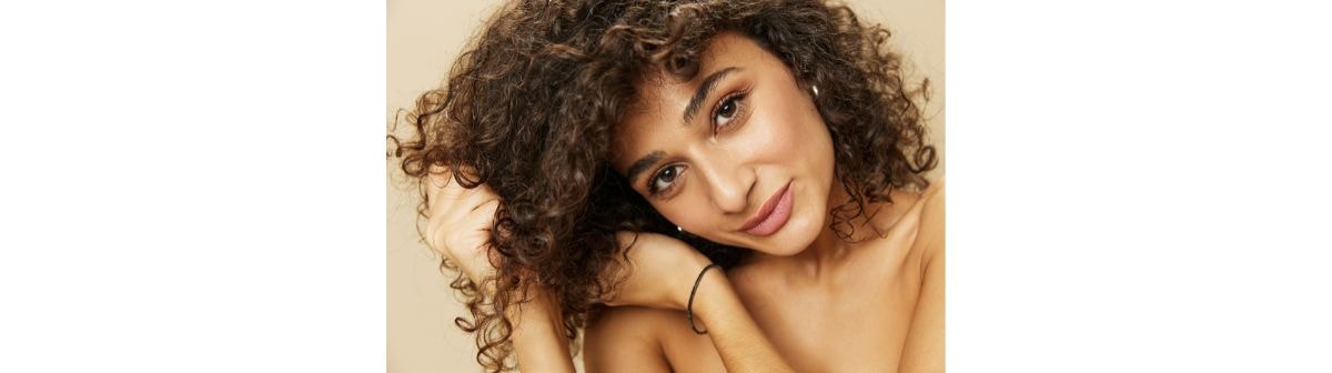 Jovem mulher com o cabelo castanho claro e cacheado