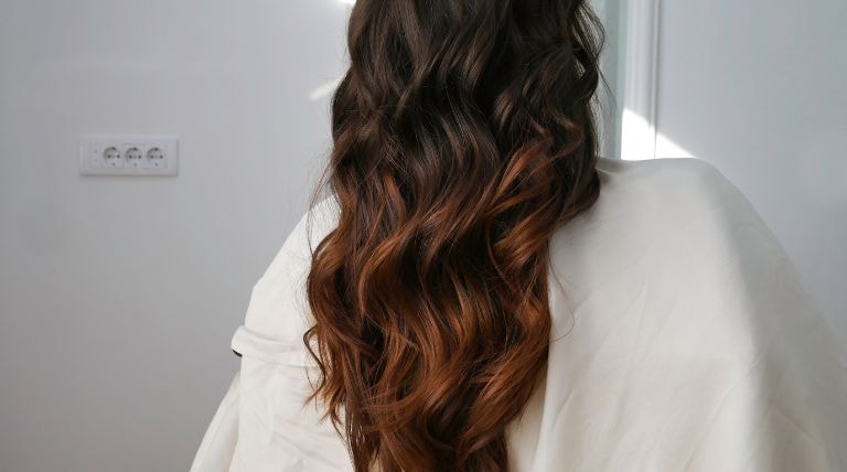 Mulher com o cabelo de cor morena iluminada mel