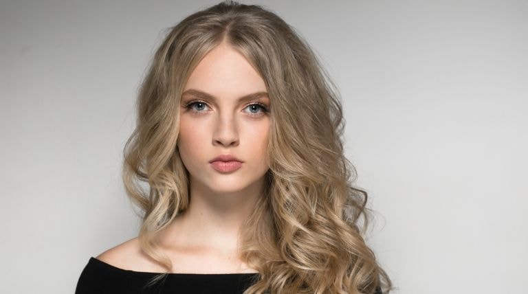 Jovem com o cabelo ondulado de cor loiro cinza claro