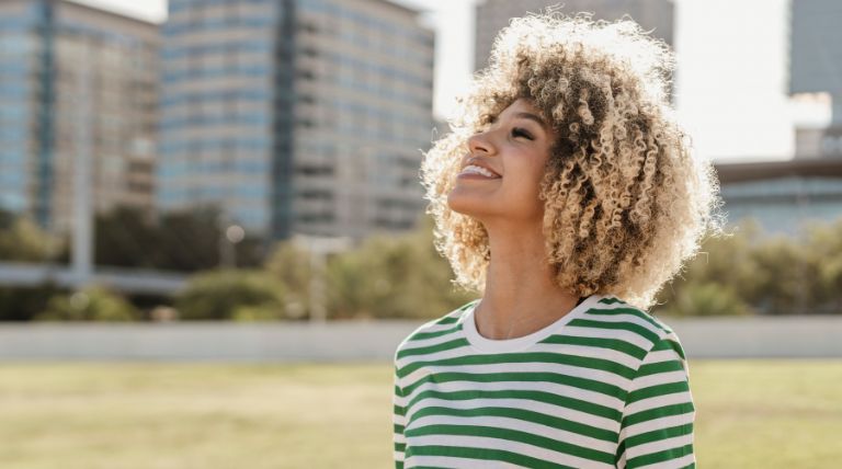 Jovem com o cabelo crespo com pontas de cor loiro iluminado perolado