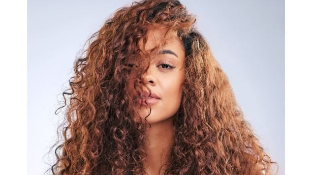 Mulher com cabelo louro mel cacheado