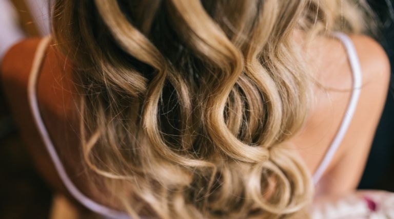 Visão traseira do cabelo loiro iluminado loiro de uma mulher