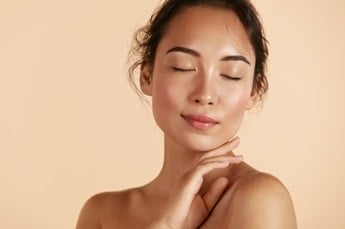 Mulher com a pele bonita e radiante ao usar ácido hialurônico com vitamina c
