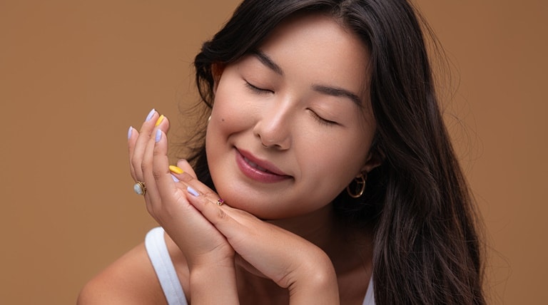 Mulher asiática com pele macia ao usar os benefícios do ácido hialurônico