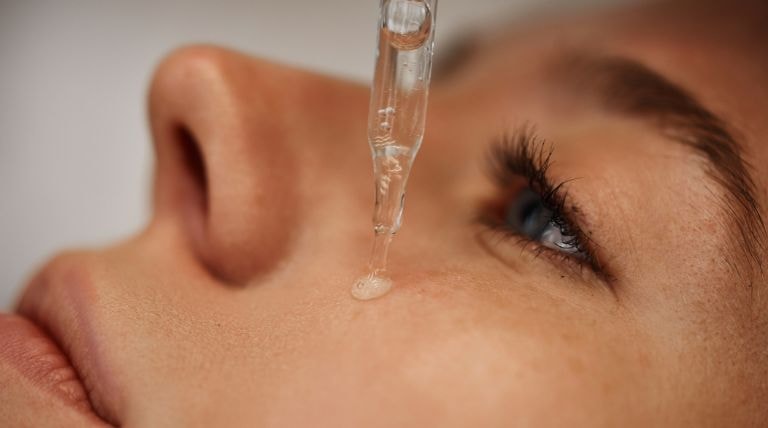 Mulher aplica sérum com ácido lático para clarear a pele