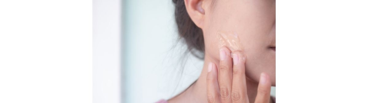 Mulher aplica suavemente gel de babosa ou aloe vera na pele