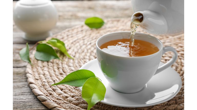 Chá verde sendo adicionado em uma xícara para o consumo diário