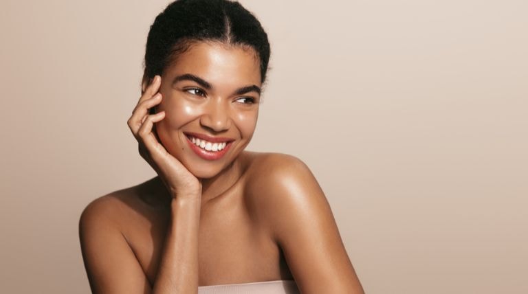 Jovem negra com a pele radiante demonstra para que serve o colágeno