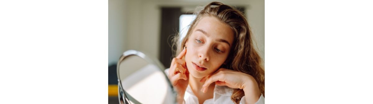 Jovem analisa sua pele e quais cuidados com a pele serão necessários no inverno