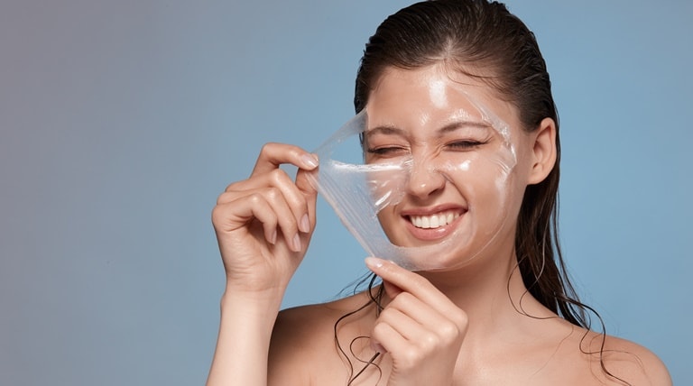 Jovem ilustra a remoção das células mortas da pele ao usar esfoliante químico