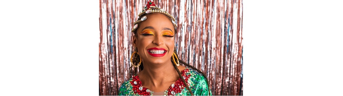 Jovem feliz sorri de olhos fechados com sua maquiagem de carnaval