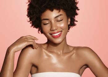 Jovem negra com a pele iluminada por usar a niacinamida na pele