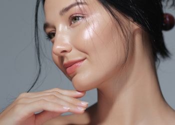 Jovem caucasiana aplica niacinamida na pele para garantir sua uniformidade