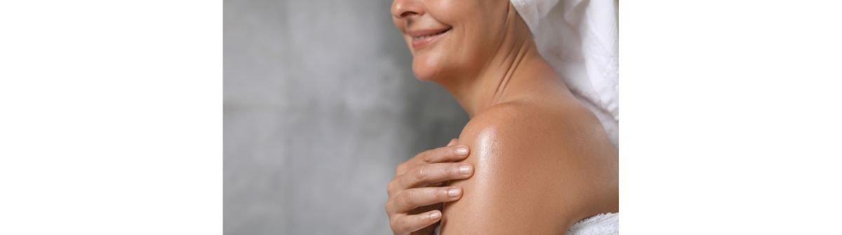 Mulher feliz aplicando óleo corporal para hidratar a pele