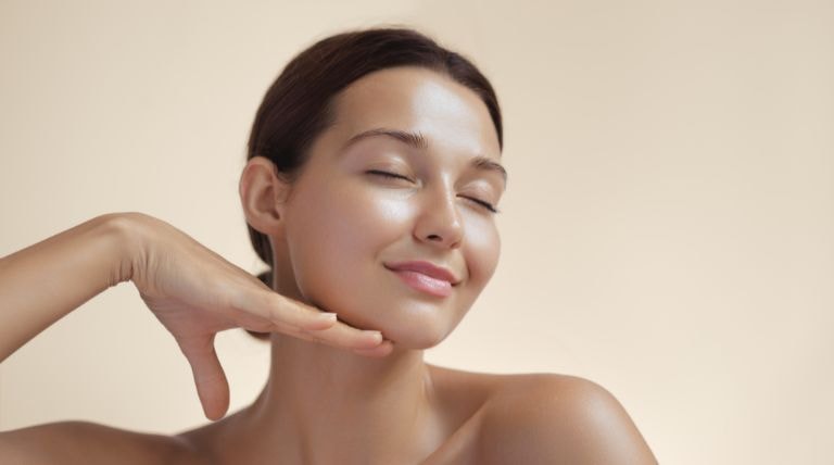 Jovem caucasiana com a pele facial uniforme e radiante depois do peeling químico