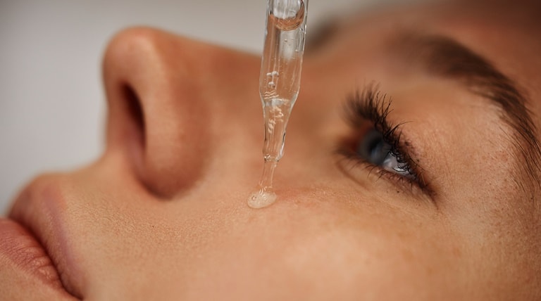 Mulher aplica sérum com ácido lático para clarear a pele