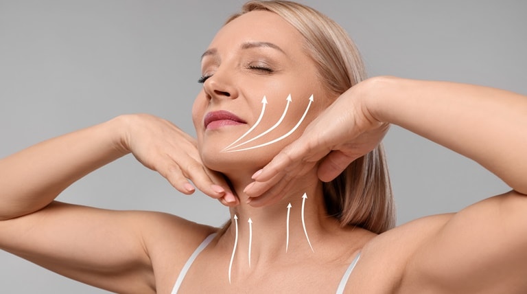 Mulher com pele madura demonstra como utilizar o hidratante facial para o rosto