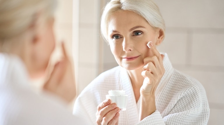 Senhora aplica creme de hidratação para manter a pele macia, hidratada e jovem