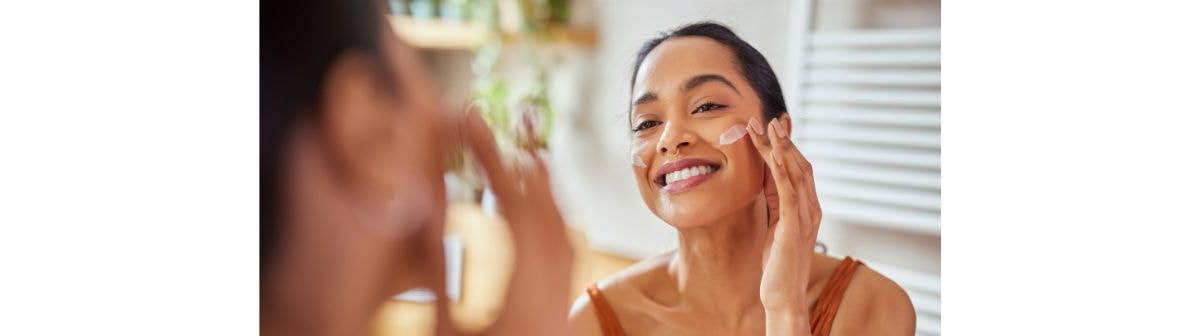 Mulher hispânica ou latina utiliza hidratante facial no verão 