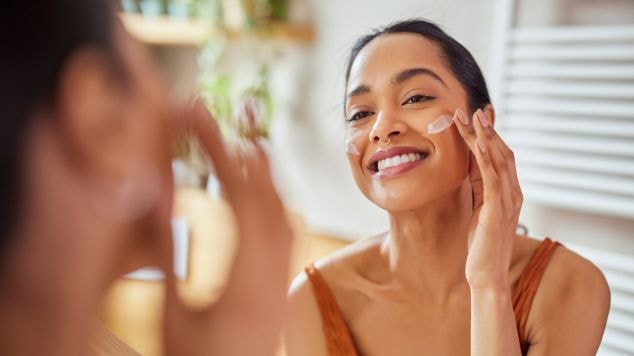 Mulher hispânica ou latina utiliza hidratante facial no verão