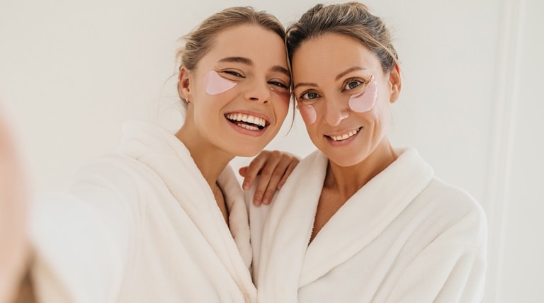 Mulheres sorriem ao manter os cuidados para ter uma pele macia e rejuvenescida