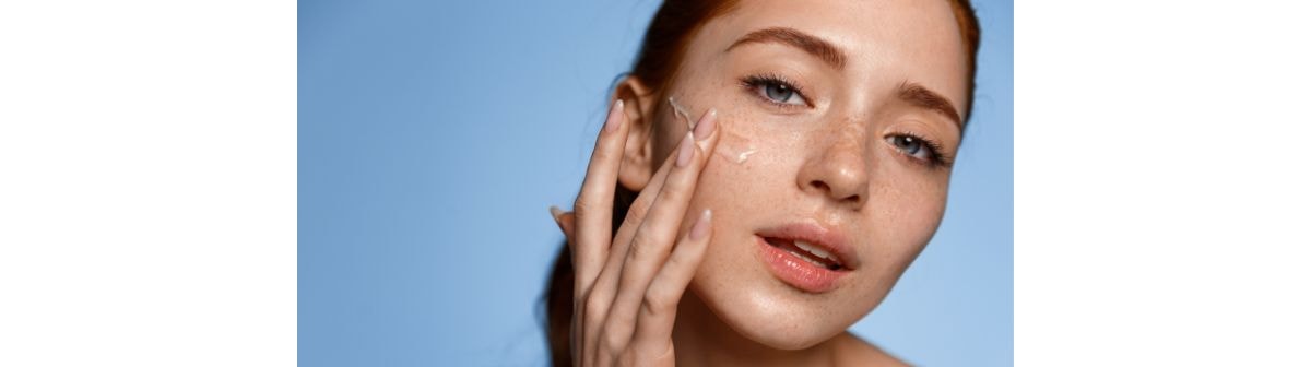 Jovem aplicando hidratante facial do seu potinho de hidratante