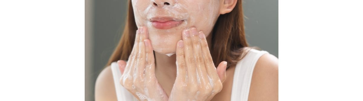Parte inferior do rosto de uma jovem limpando o rosto com o sabonete com ácido salicílico para reduzir acne e oleosidade