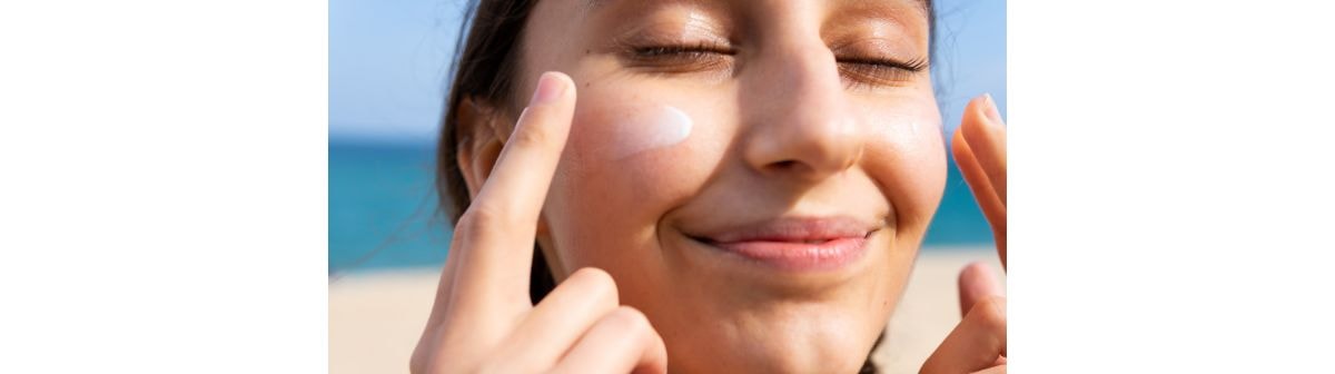 Mulher sorridente ao aplicar o filtro solar 