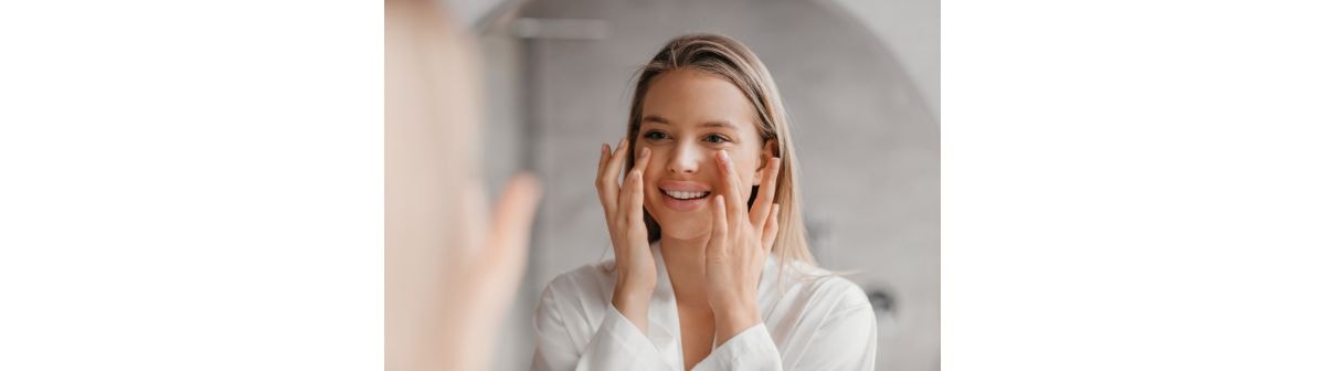 Jovem aplica creme com antioxidantes para a pele do rosto