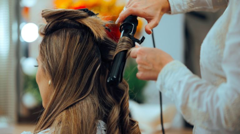 Mulher com o cabelo castanho marrom chocolate fazendo a finalização no salão de beleza.