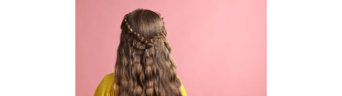 Jovem de costas mostrando o seu cabelo loiro escuro e longo.