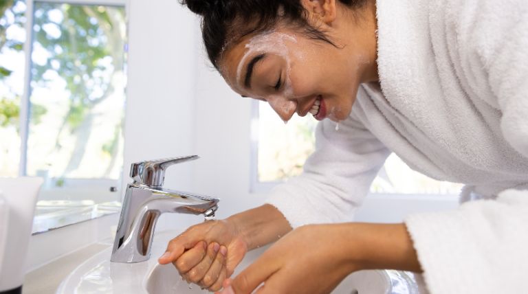 Jovem garota realiza a limpeza facial ao preparar a pele para sua maquiagem de carnaval
