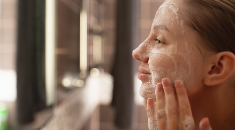 Mulher realiza a limpeza facial para pele oleosa com um gel de limpeza para pele oleosa.