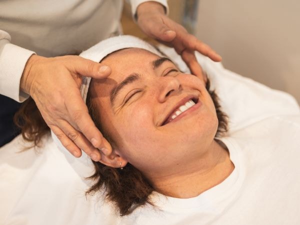 Mulher sorridente no consultório de um dermatologista ou esteticista que realizará o tratamento para reduzir os poros dilatados.